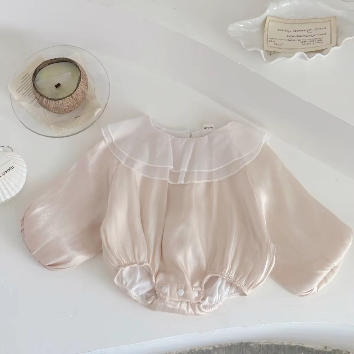 Newborn and toddler white romper with ruffles and back button closure