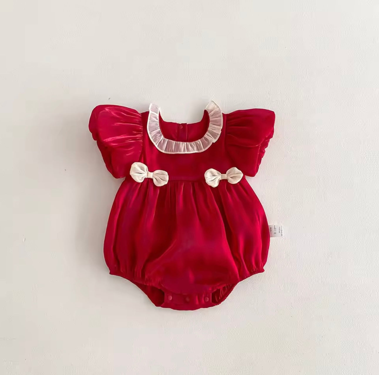 Festive holiday romper for babies with ruffled neckline and classic design.