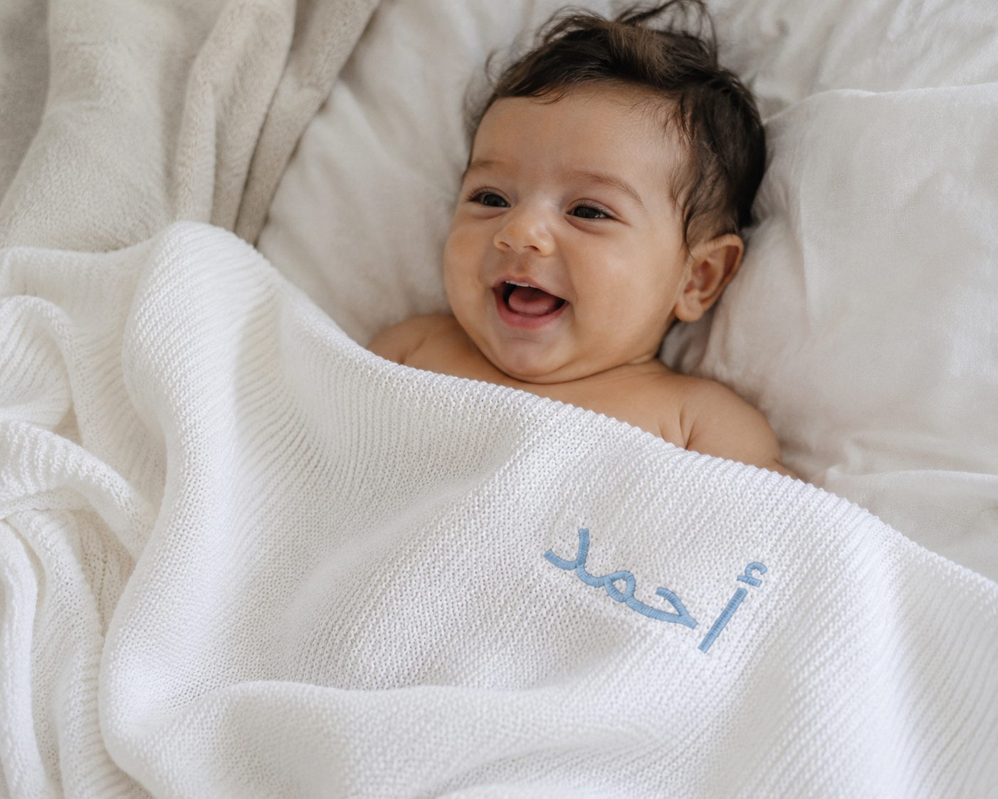 Folded personalised white baby blanket styled as luxury newborn gift — perfect baby shower and Aqiqah gift in Dubai UAE
