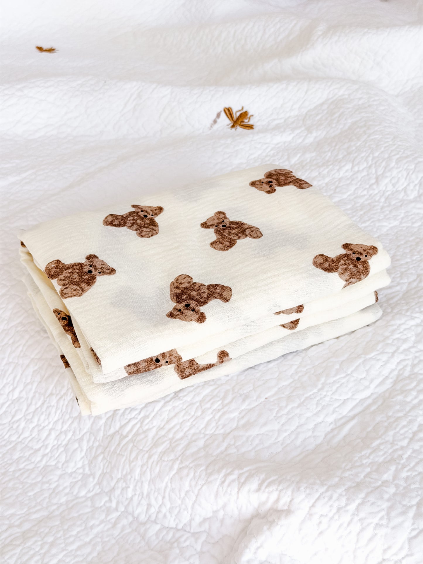 Close-up detail of cream muslin baby blanket showing brown teddy bear print on soft cotton fabric — Maxims baby store . baby essentials UAE
