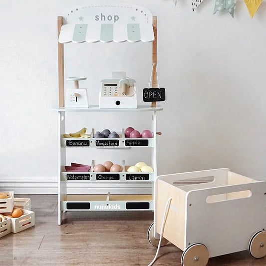 Wooden Montessori play shop with cash register, OPEN sign and pull-along wooden shopping cart, perfect for toddler role play.