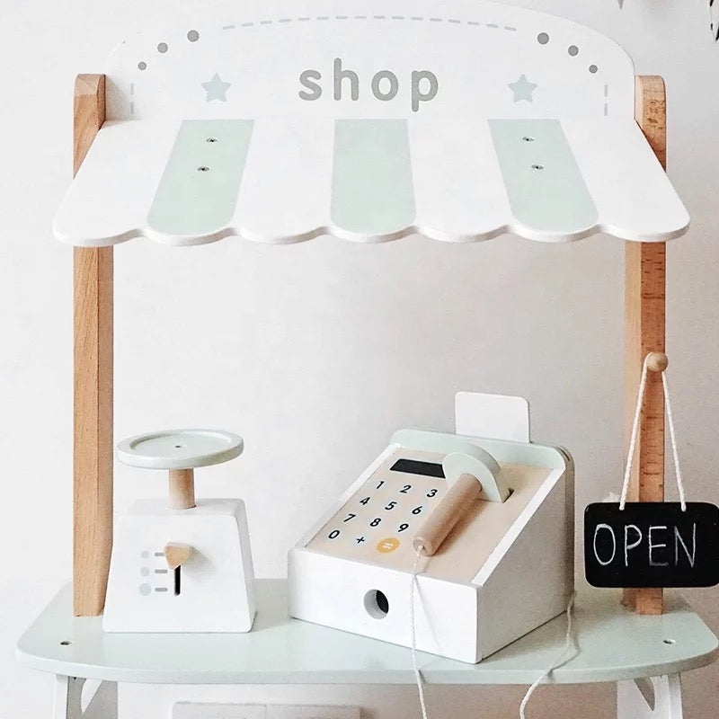 Close-up of wooden cash register, coffee machine and OPEN chalkboard sign from the Maxim’s Montessori play shop set.
